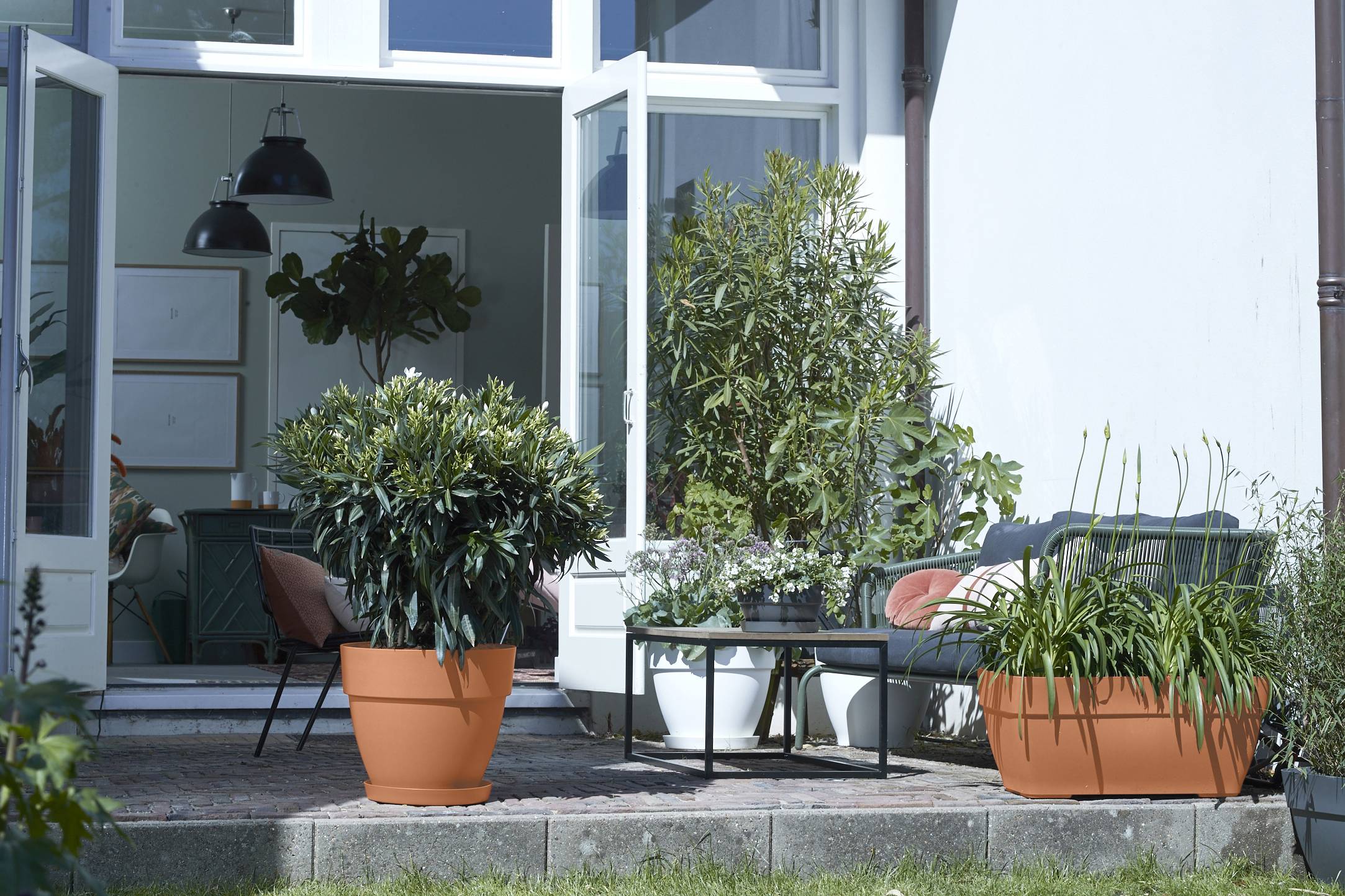 A garden seating area with large Elho planters